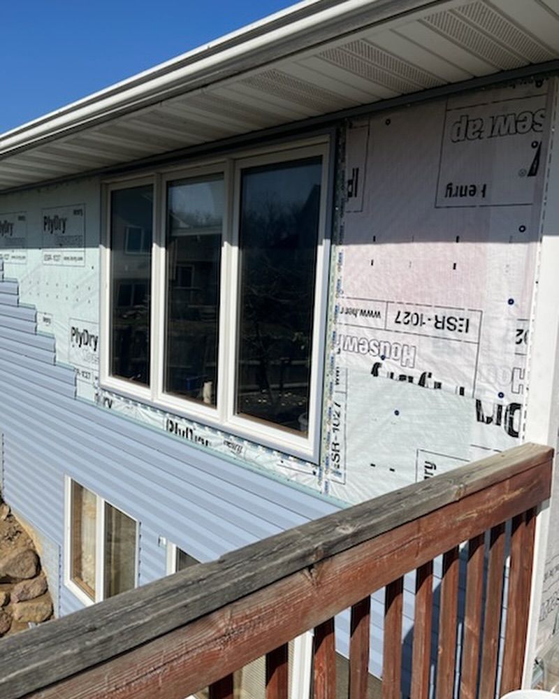 A house with a lot of windows and a wooden railing.
