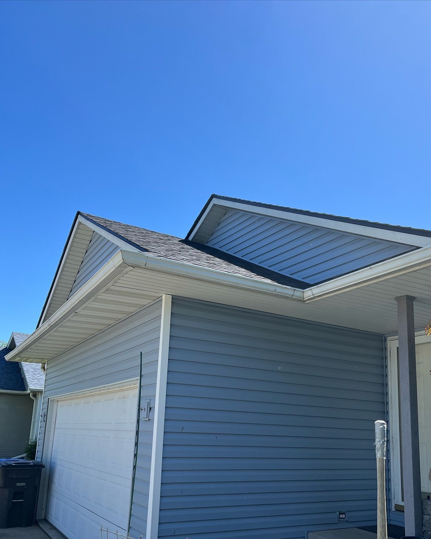 A house with a garage and a blue sky in the background