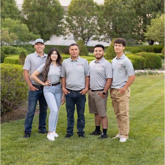 A group of people are posing for a picture in a grassy field.