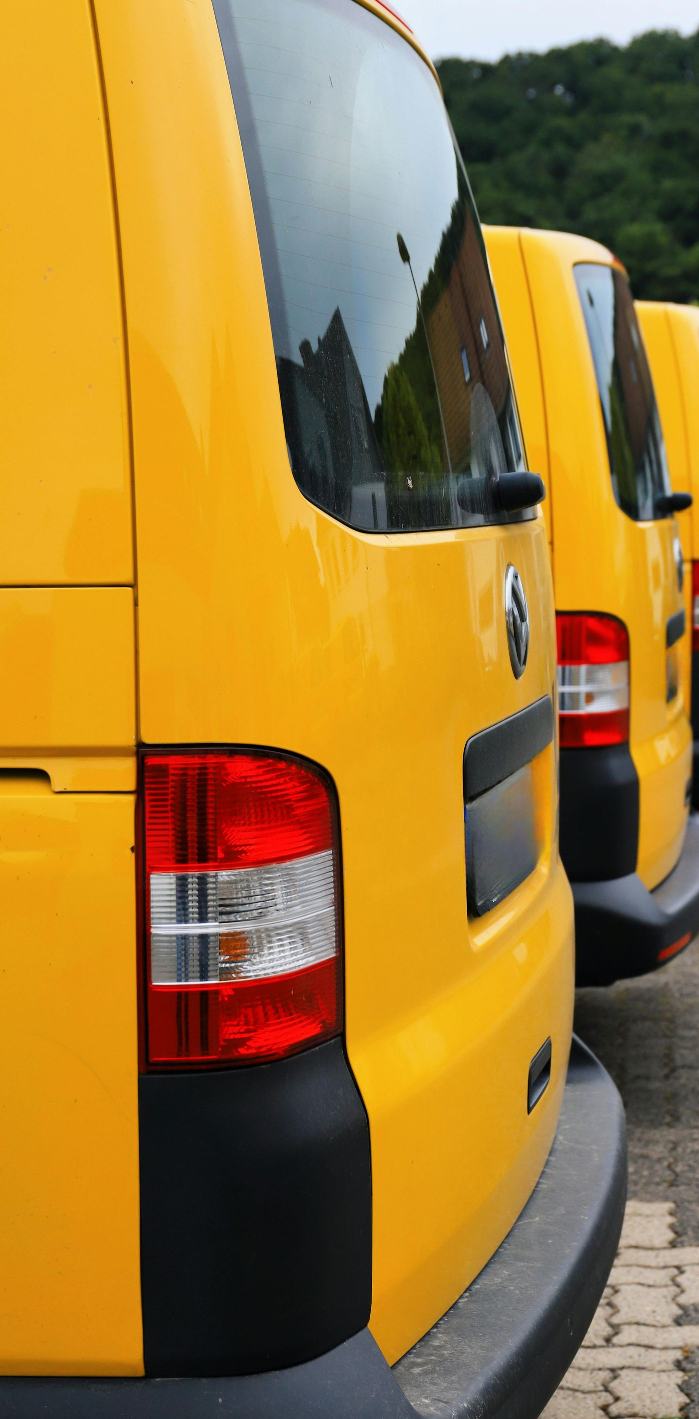 Yellow delivery vans parked in a row, taillights visible.