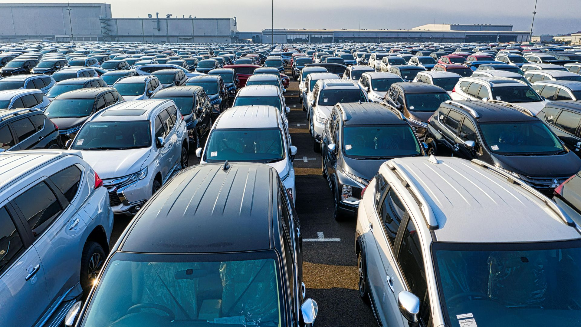 Cars parked closely together in a large lot, likely for storage or sale.