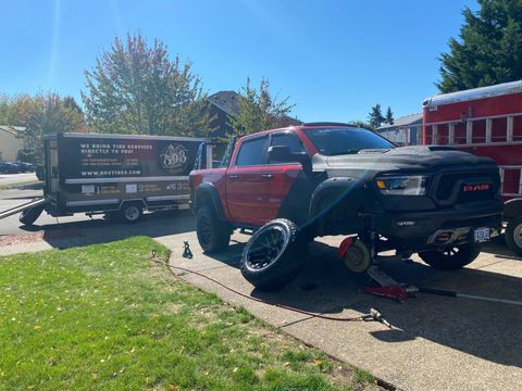 Red truck getting it's wheels taken off.