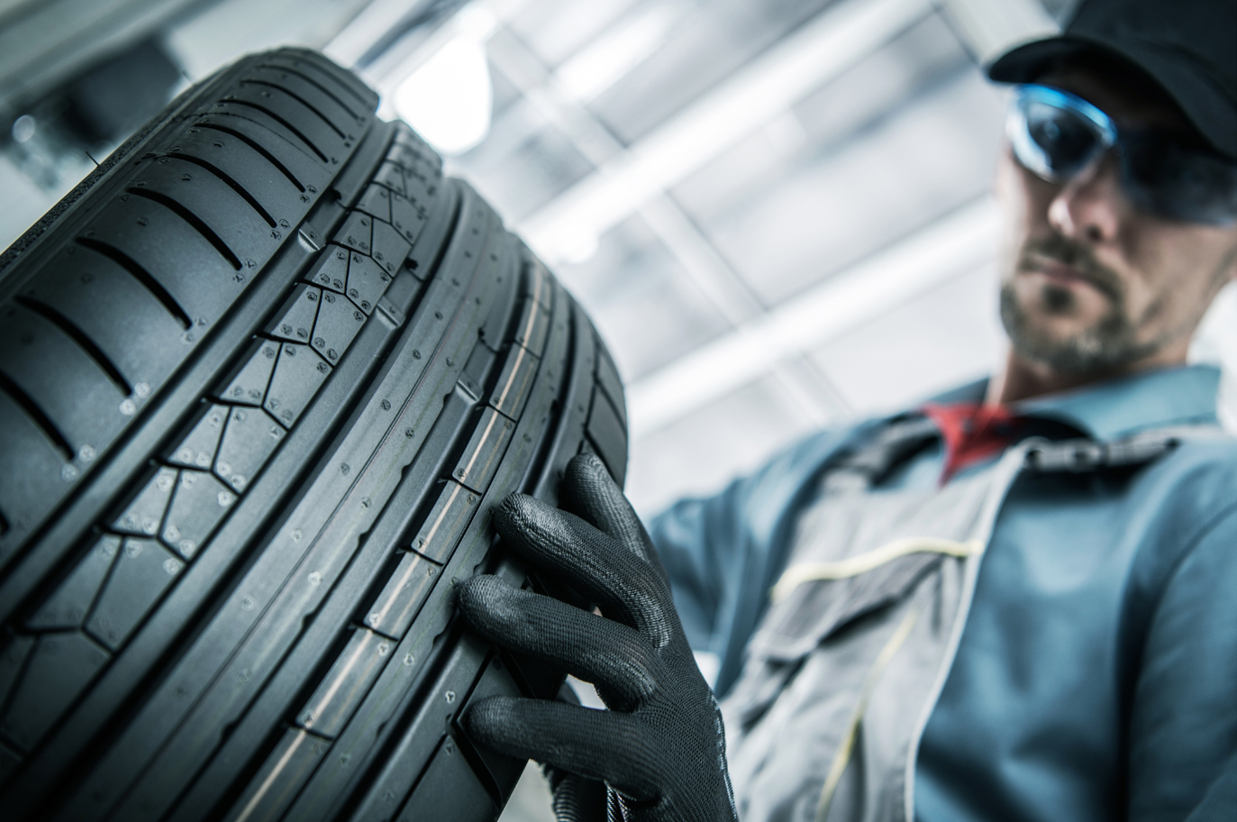 Car mechanic replacing car tires with a new one