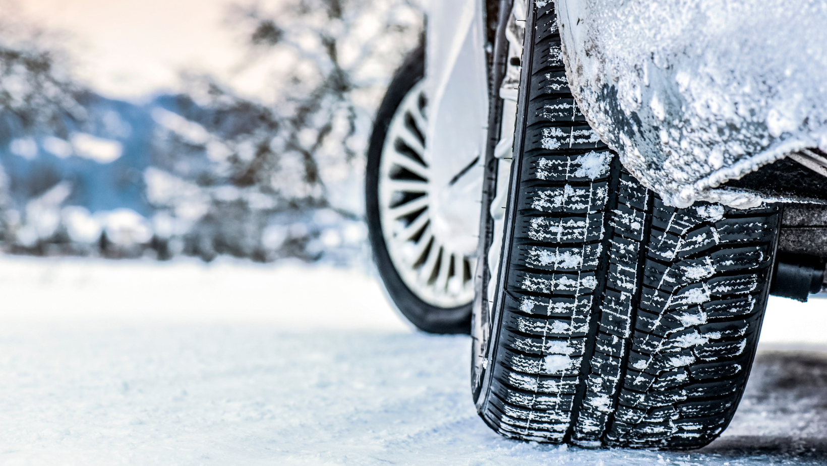 Close-up photo of winter tires on a snowy road.