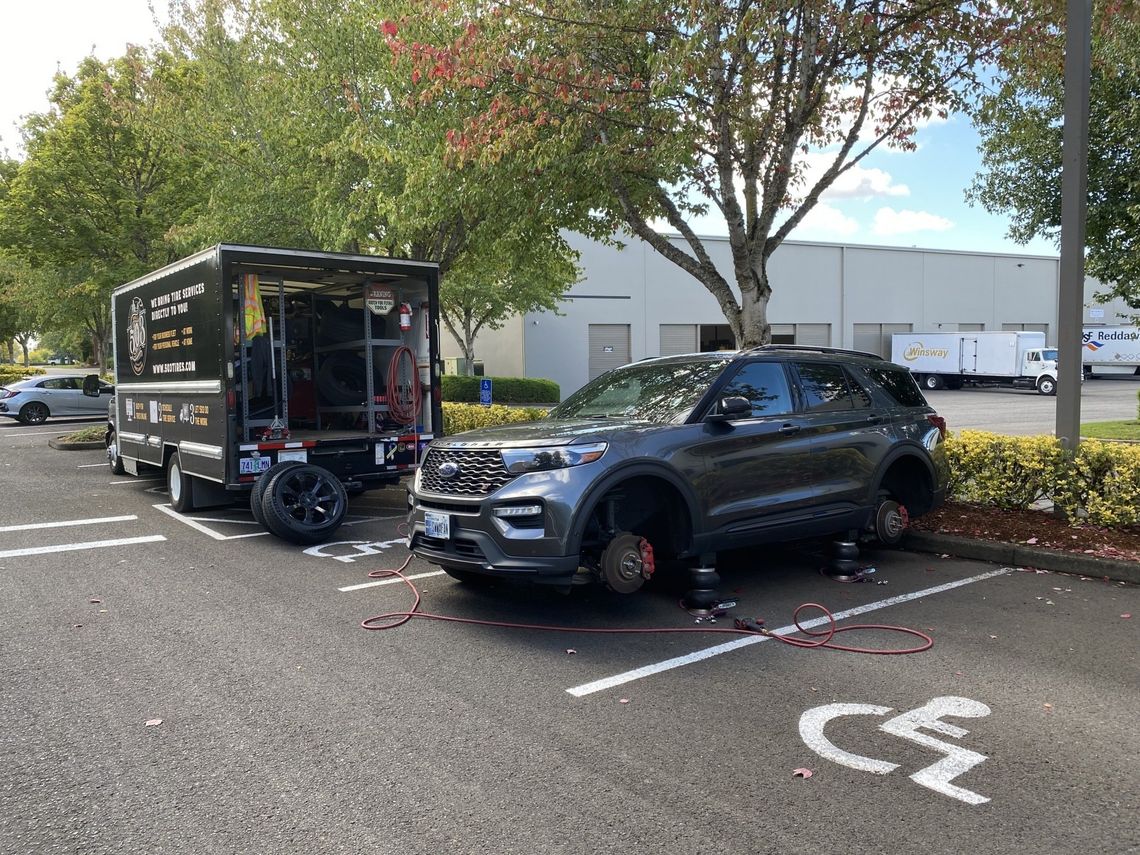 Picture of a medium size SUV getting new tires.