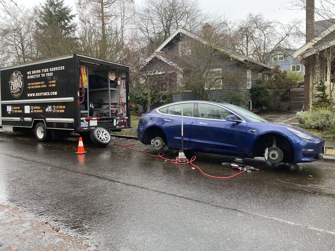 Picture of a sedan getting new tires.