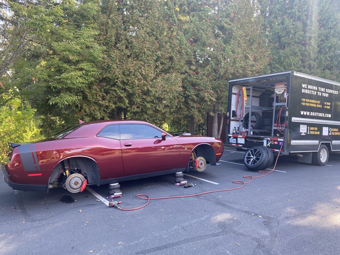 New Tires getting put on a red sports car.