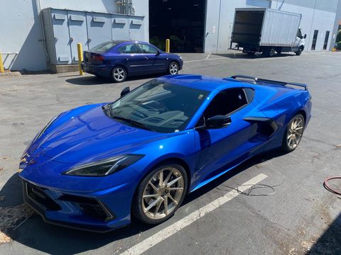 Blue sports car after it's tires have been replaced.