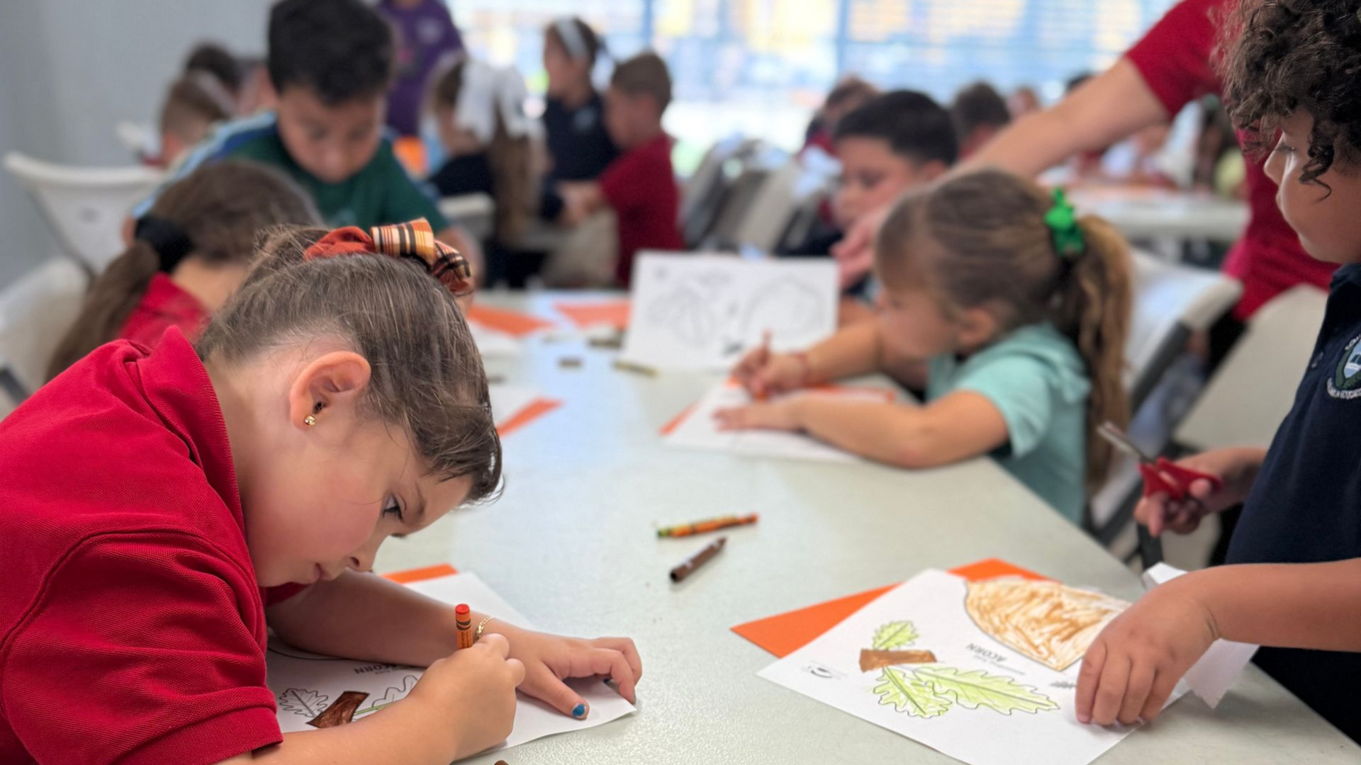 Woman reading a book with three children at a round table.