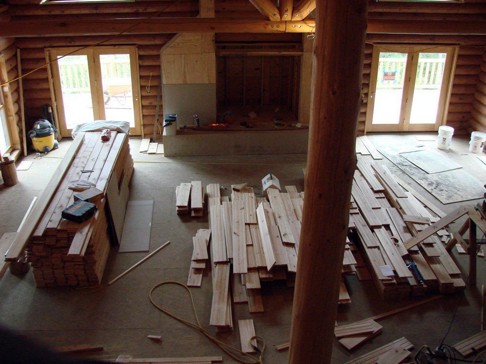 A room with a lot of wood laying on the floor.
