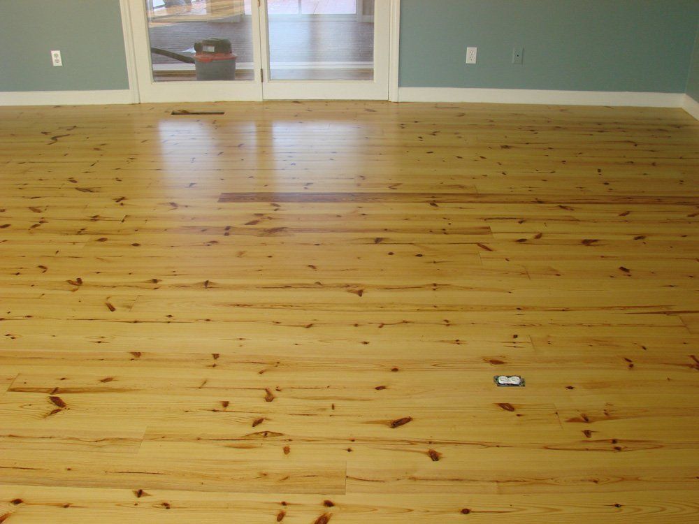 A room with a wooden floor and a sliding glass door.