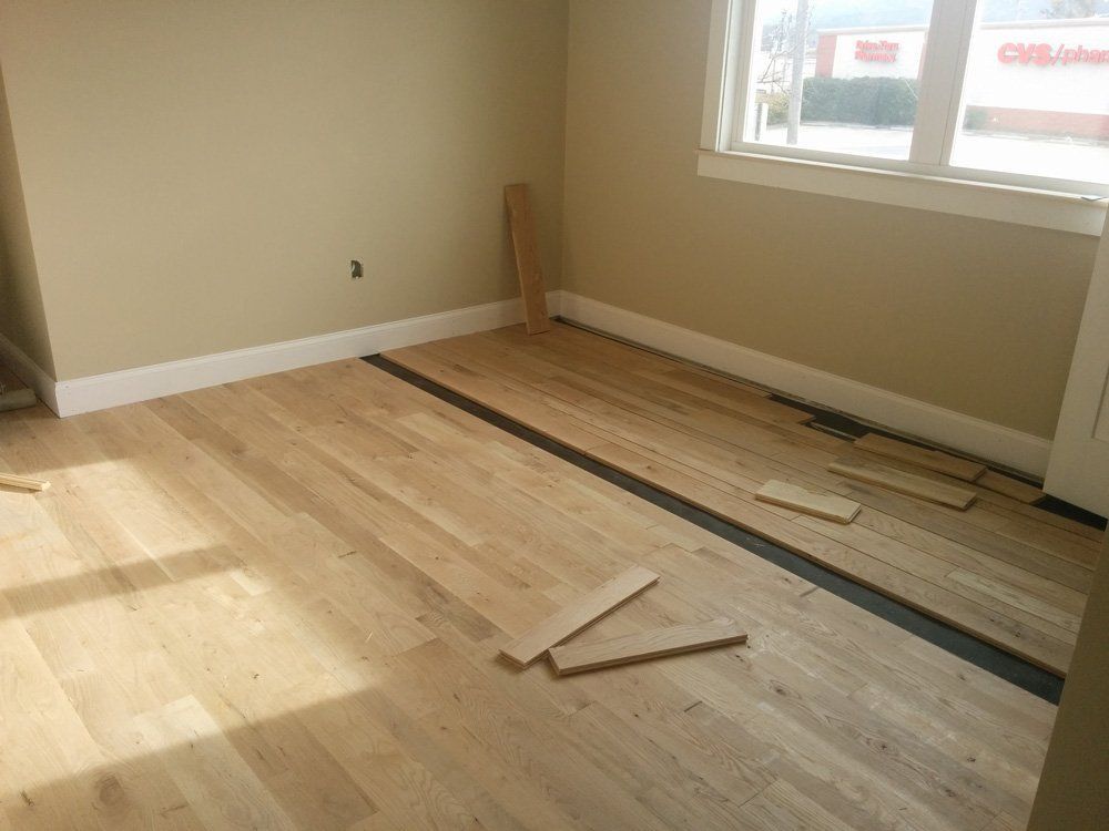 A room with a hardwood floor and a window.