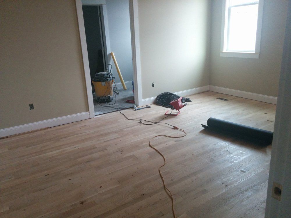 A room with hardwood floors and a vacuum cleaner on the floor.