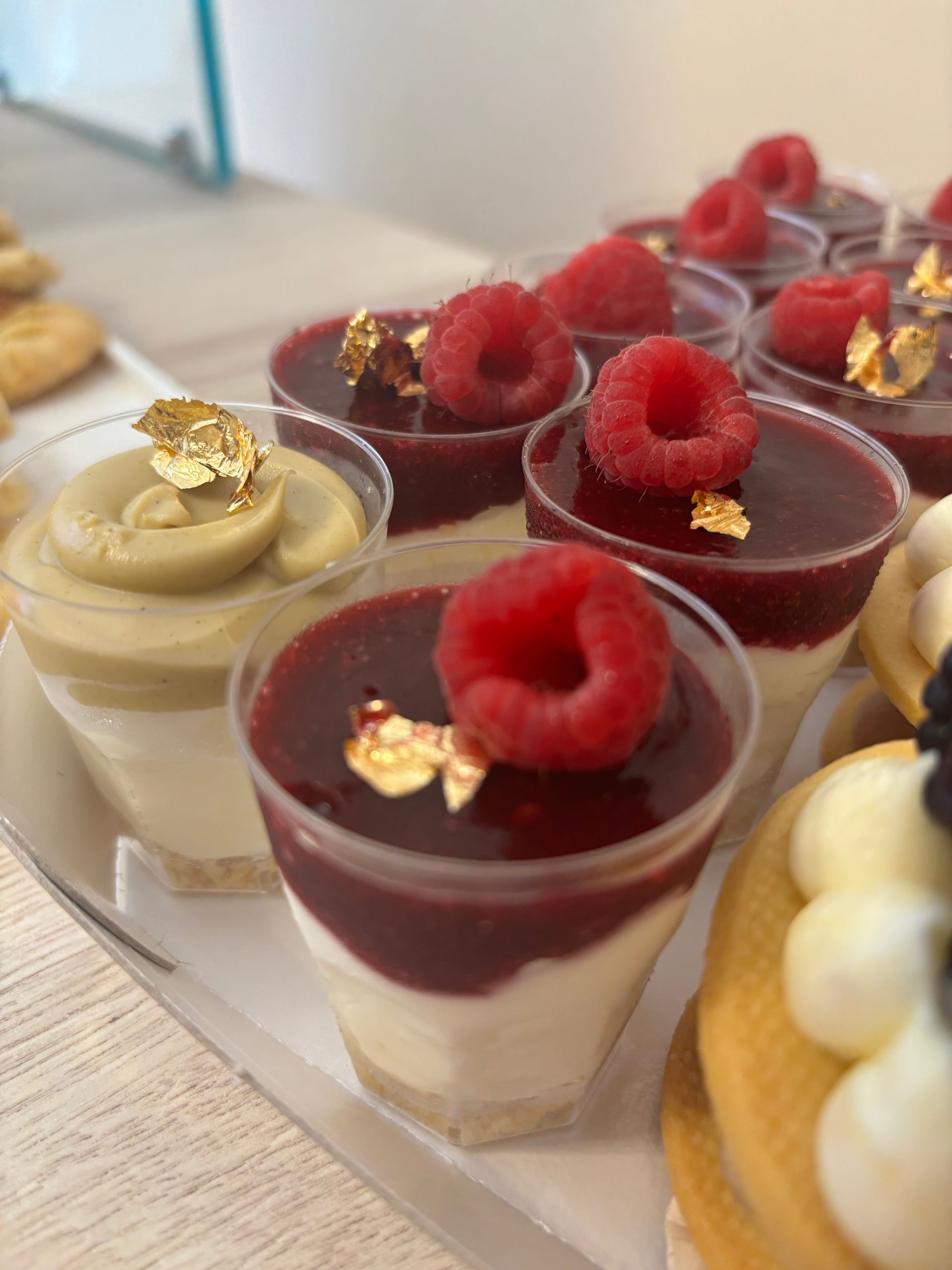 Un cucchiaio di burro di nocciole gocciola in un bicchiere. Su un tagliere di legno ci sono pane, noci e una caffettiera.