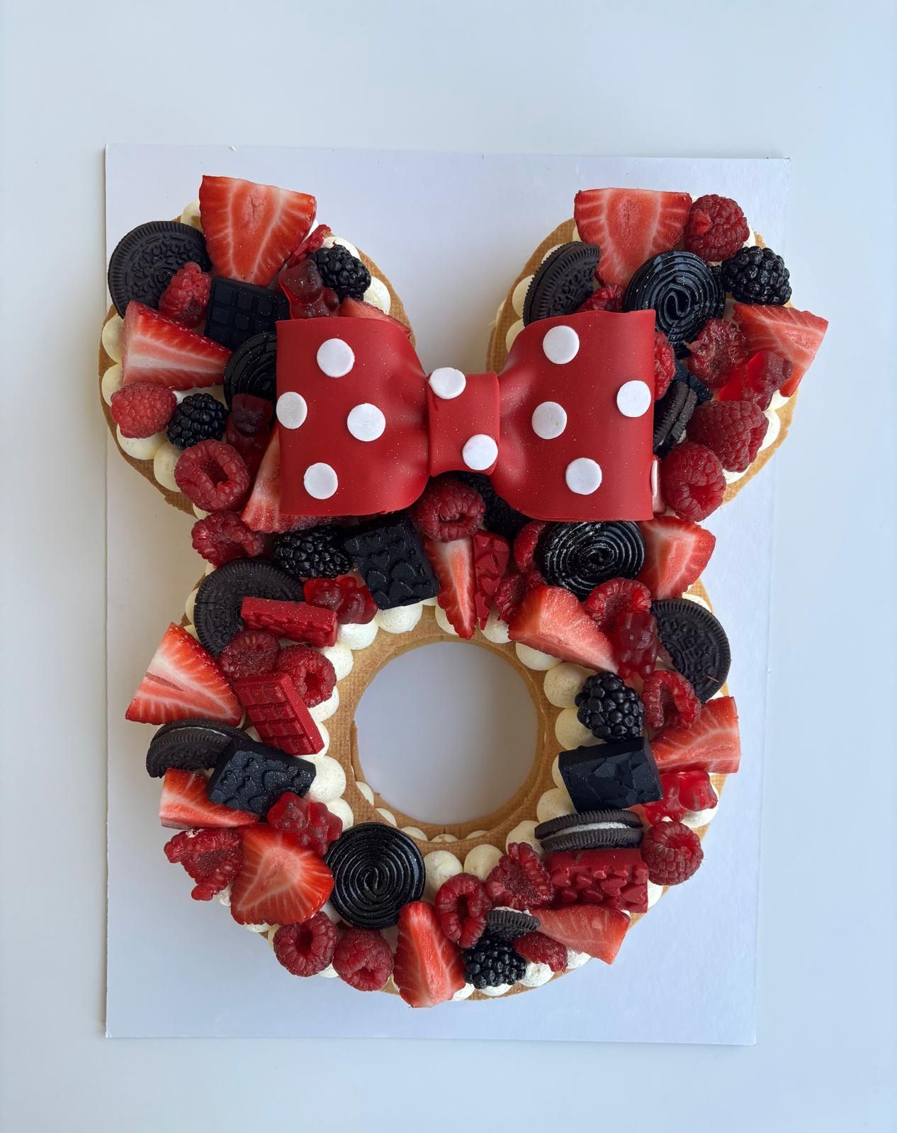 Una mano che regge una forchetta taglia una fetta di torta al cioccolato su un piatto bianco.