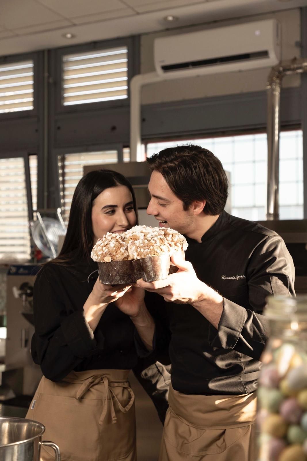 Caffè in una tazza decorata, limone, dolce e cucchiaino disposti su una tavola di legno.