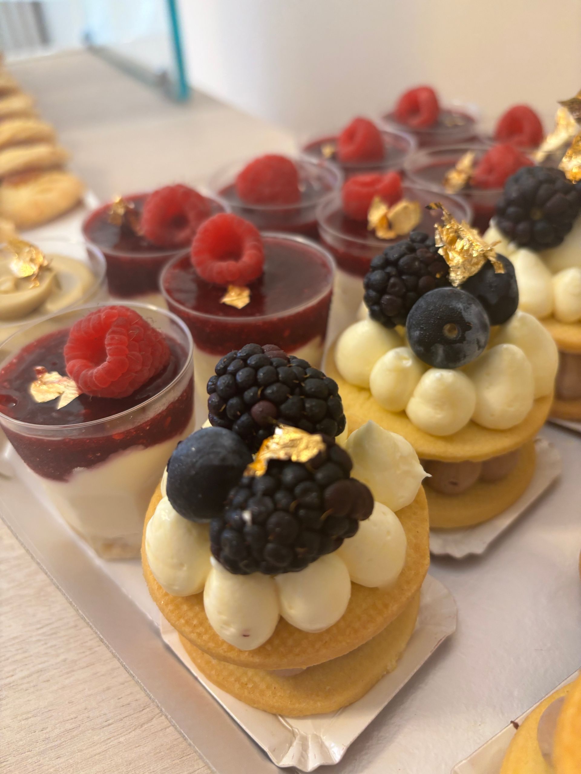 Muffin, caffè e zucchero su una tovaglia bianca, con un vaso di fiori, creano un'accogliente scena per la colazione.