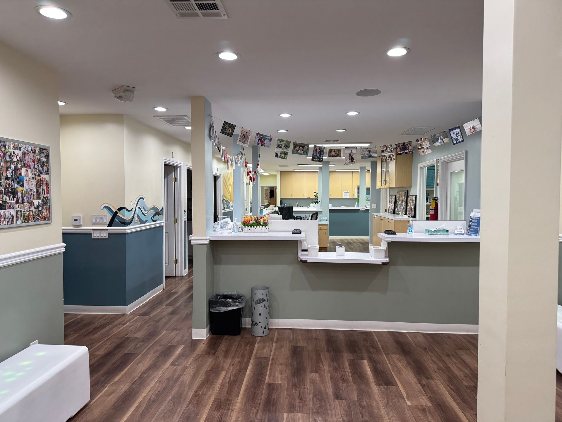 A large medical office with a wooden floor and a counter in the middle of it.