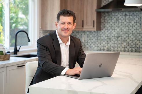 Joe in a suit and white shirt is smiling for the camera.