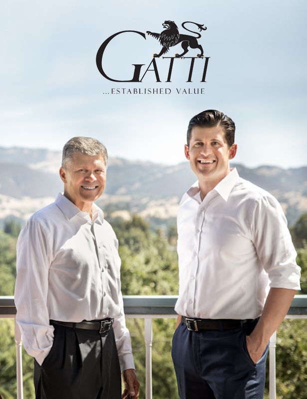 Joe and Ron Gatti are standing next to each other on a balcony.