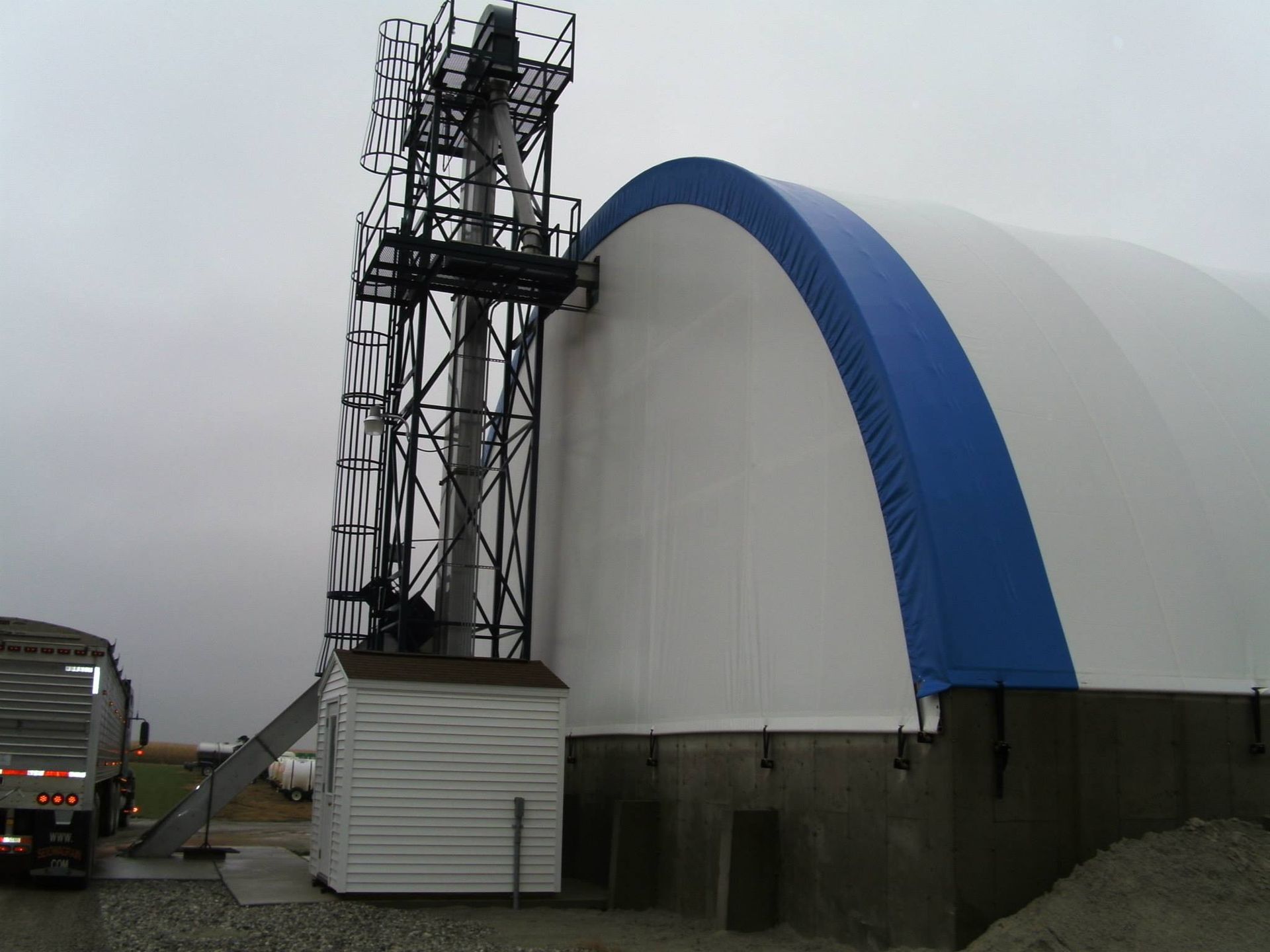 White and blue arched structure with a tall metal tower