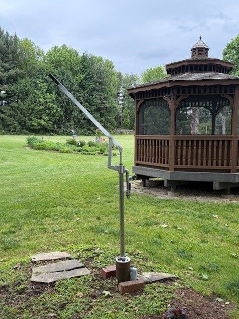A gazebo is sitting in the middle of a lush green field.