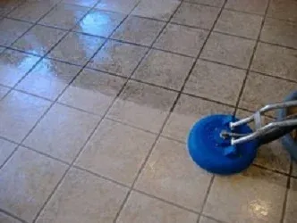 Blue cleaning tool on tile floor, half cleaned.