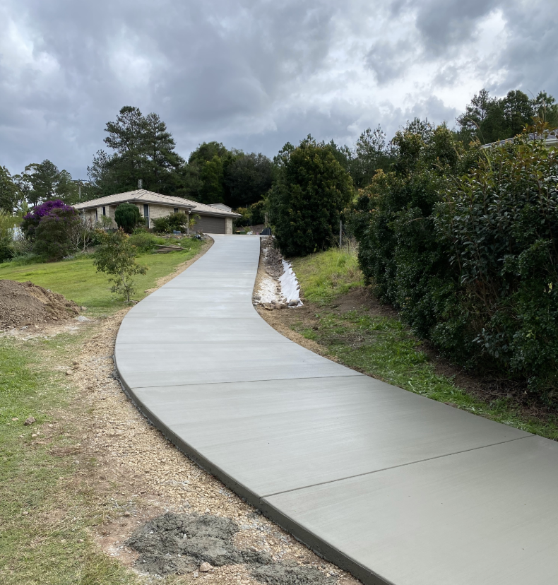 A Path Leading Up To A House With Green Hedges To The Right And Grass To The Left — Peter Bishop Concreting In Gympie, QLD
