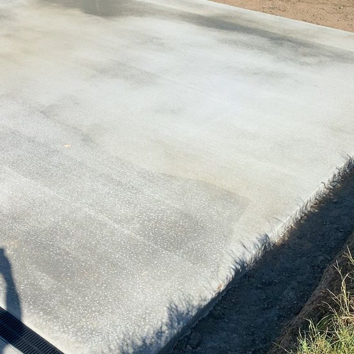 A Close Up of a Concrete Driveway With a Shadow on It — Peter Bishop Concreting In Kenilworth, QLD
