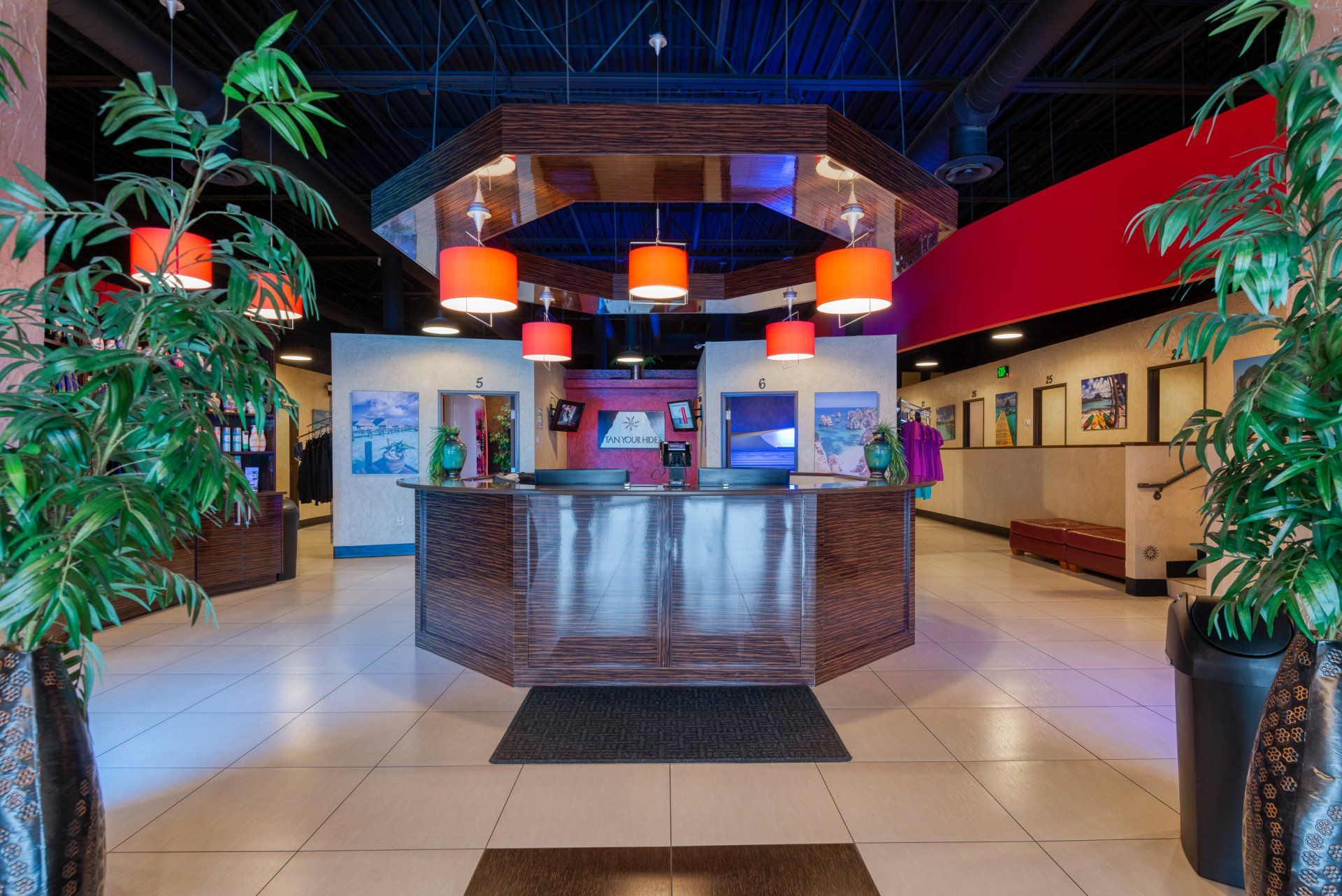 A hotel lobby with a large round counter and plants.