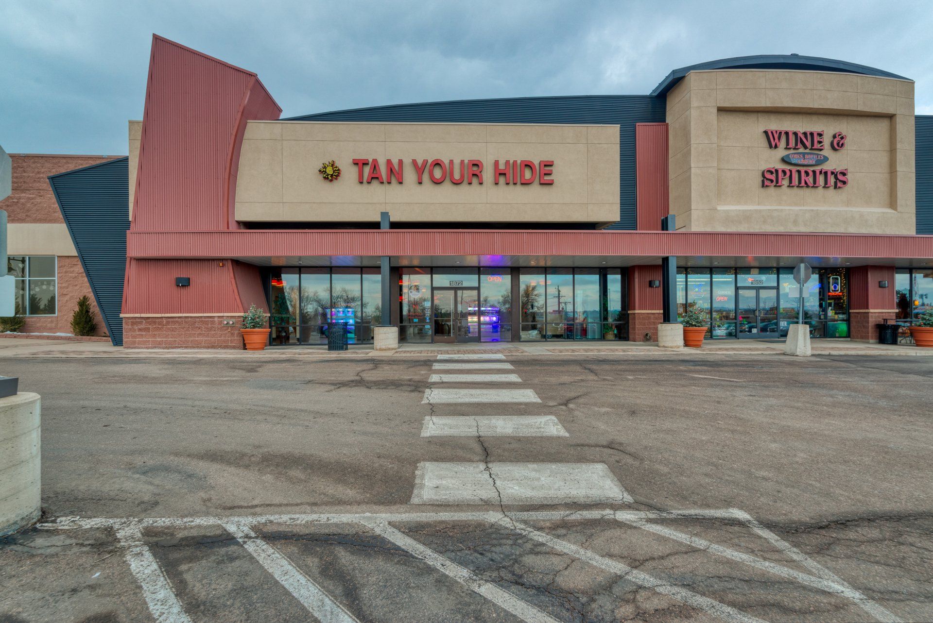 A tan your hide store with a parking lot in front of it