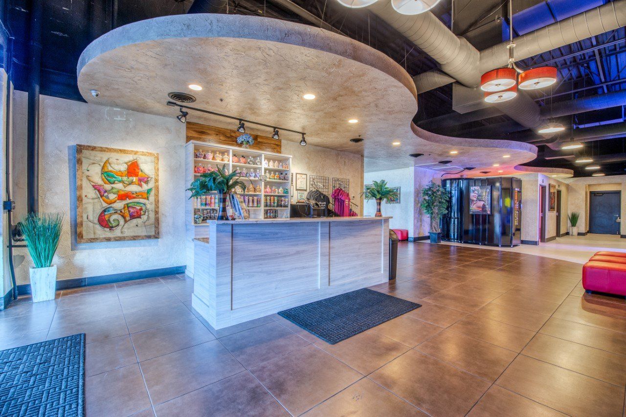 A large lobby with a reception desk and a painting on the wall.