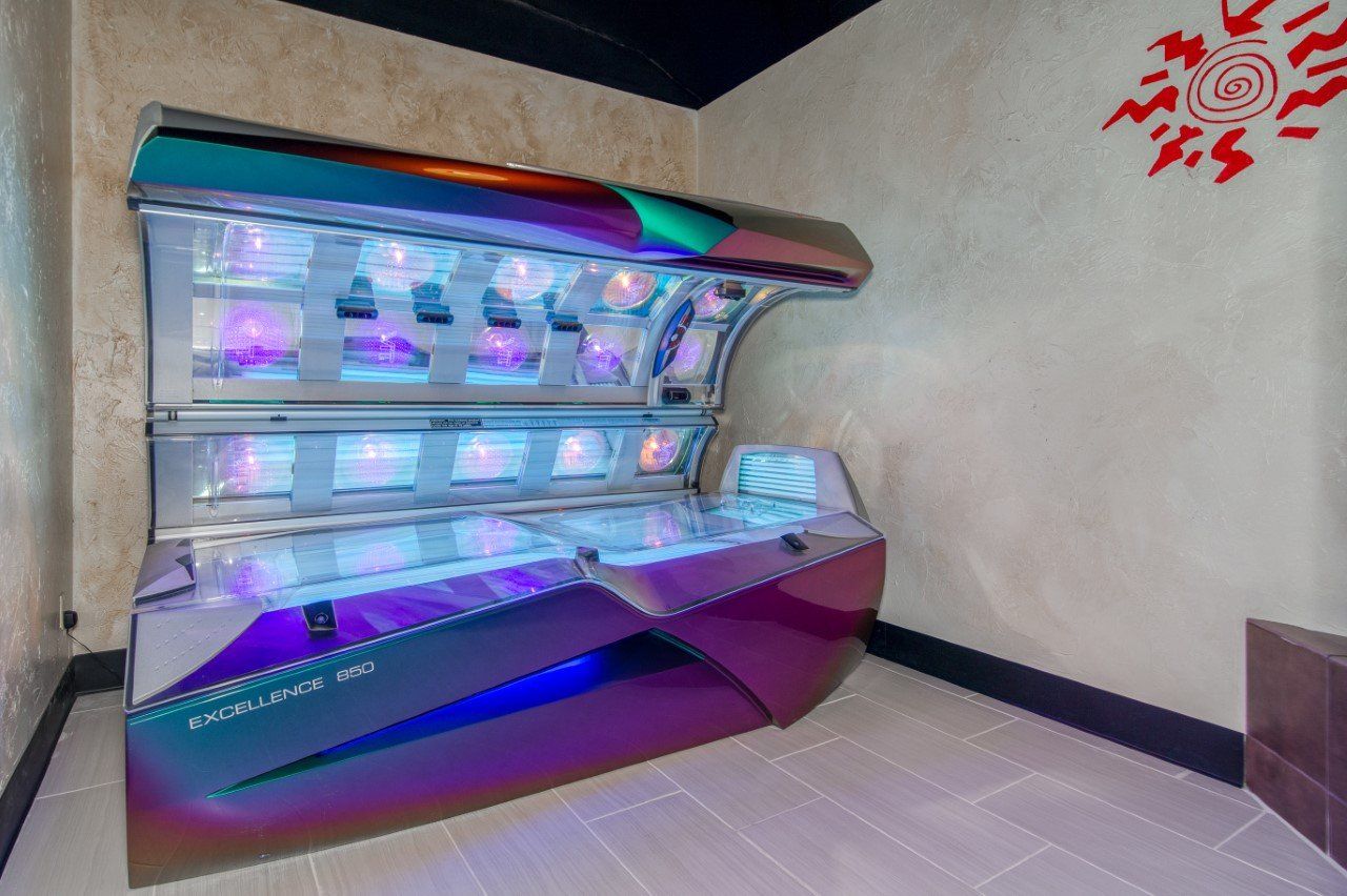 A large tanning bed in a room with a sun on the wall.