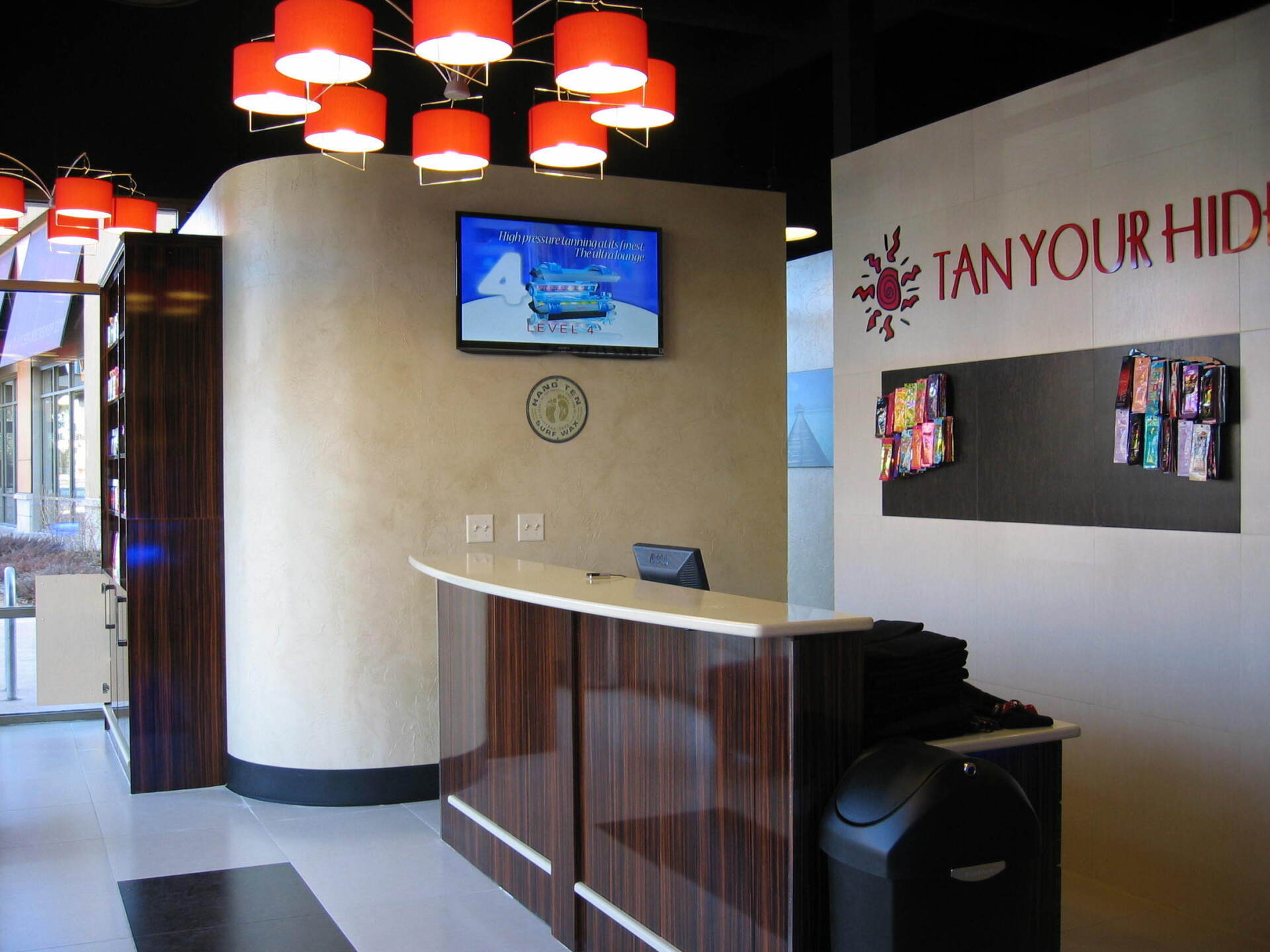 A tan your hide reception area with a clock on the wall