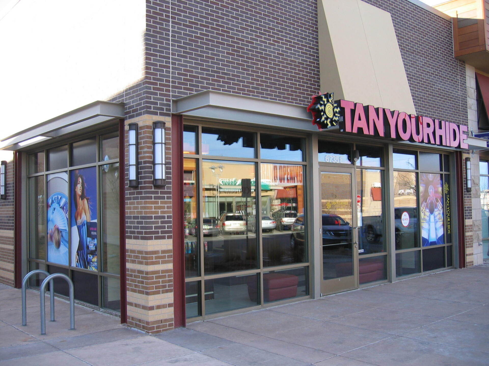 A tan your hide store is located on the corner of a brick building