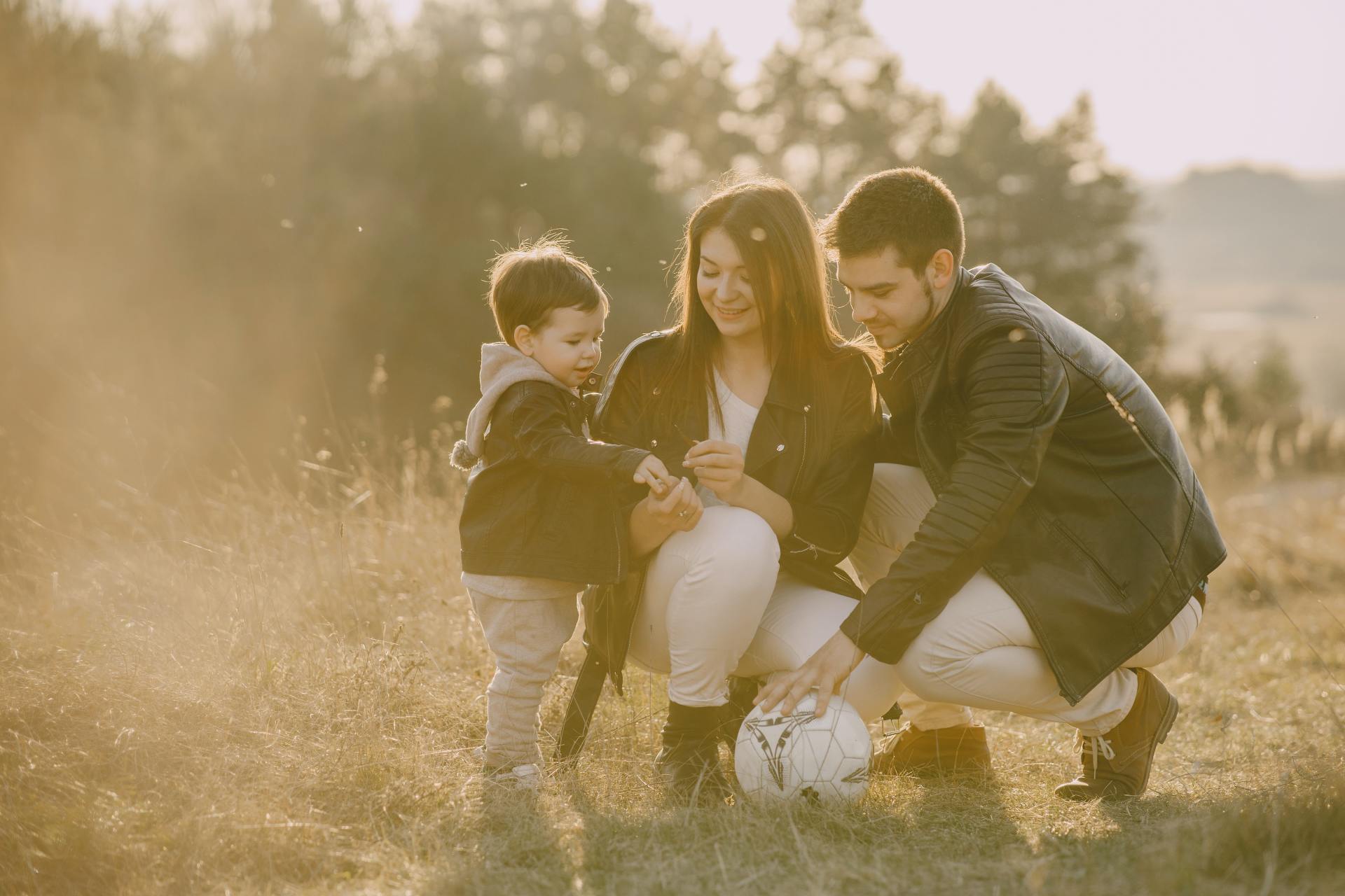 mum and dad kneeling to be closer to their young child