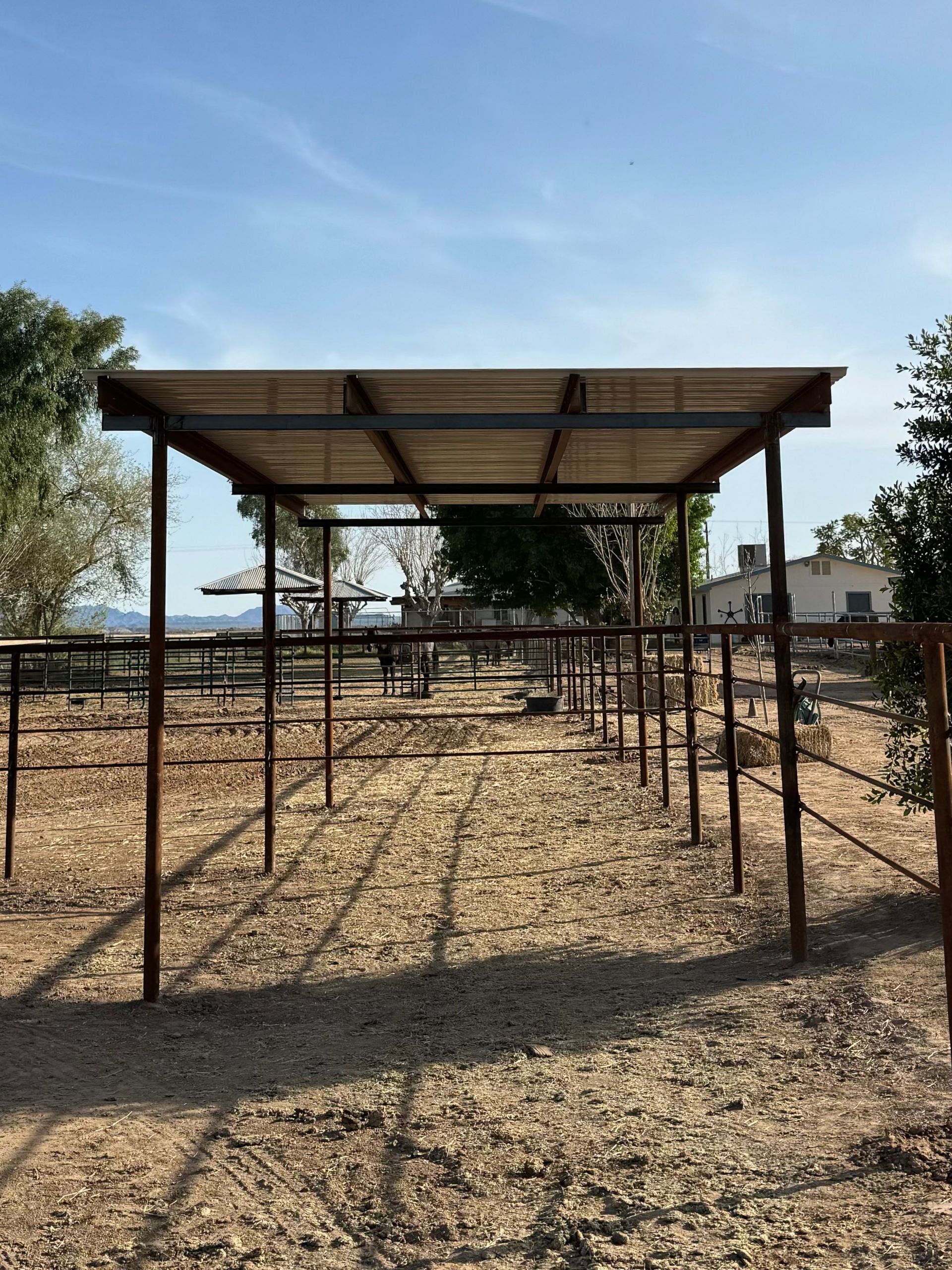 A wooden structure is sitting in the middle of a dirt field.