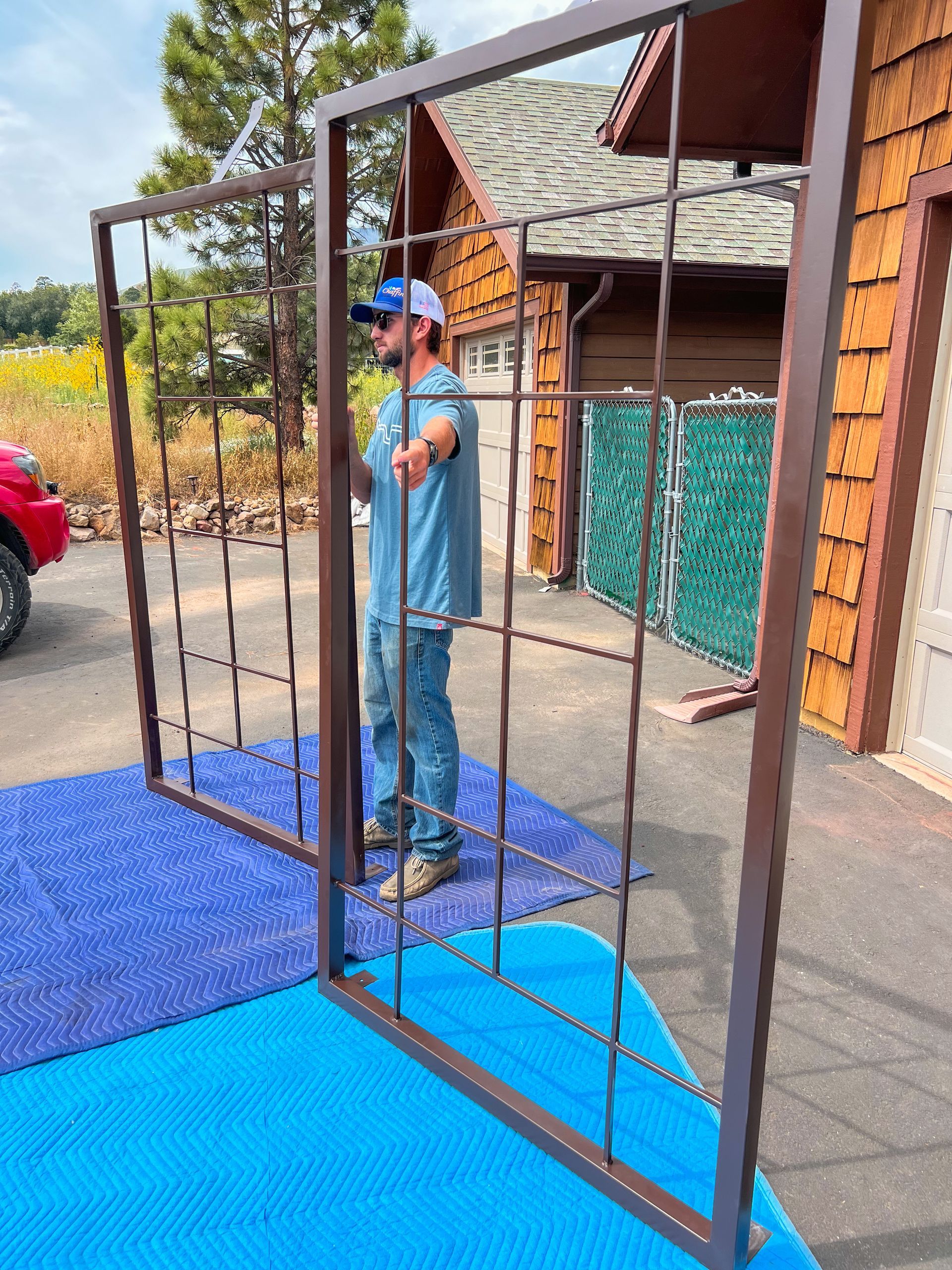 A man is standing in front of a gate that is being built.