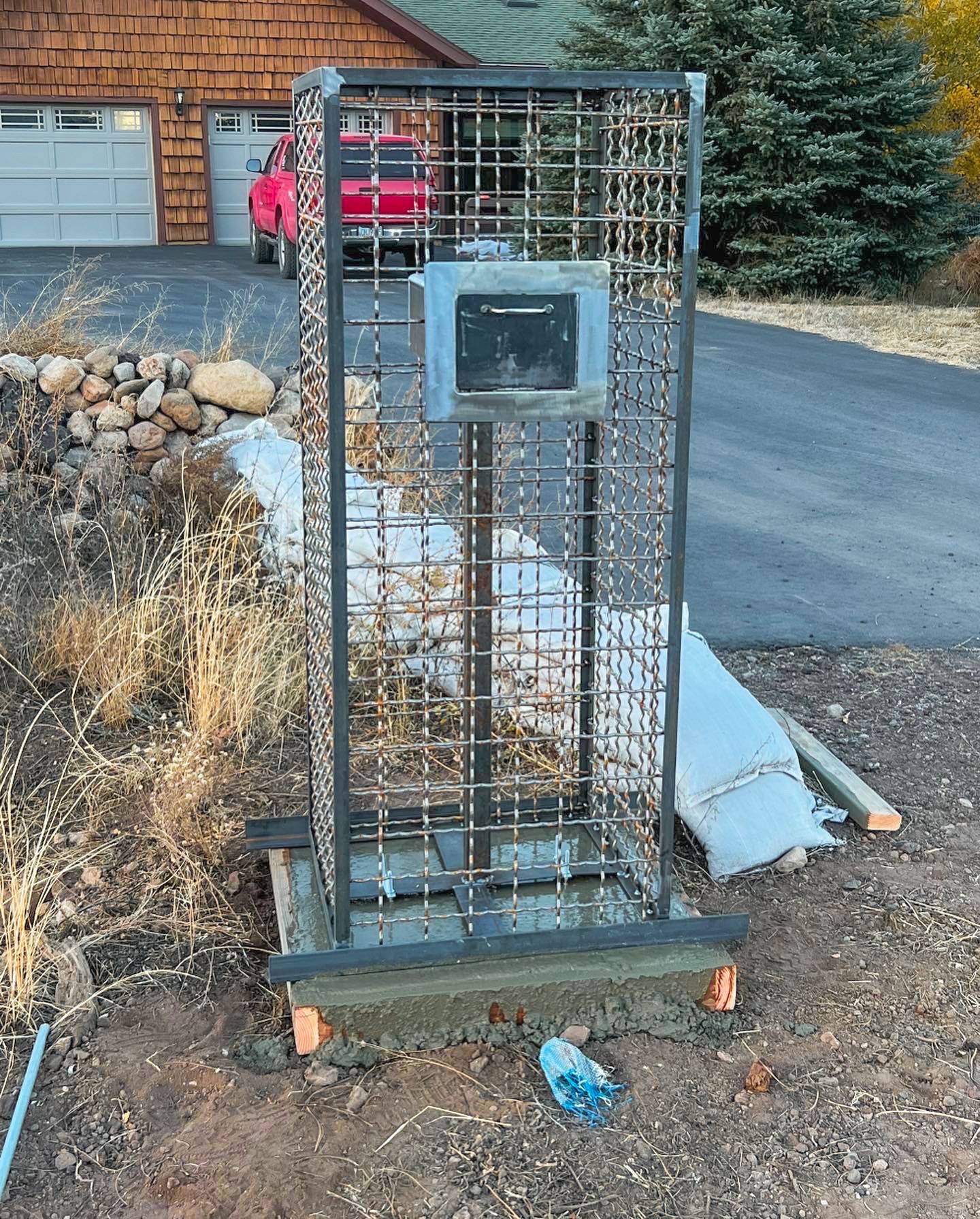 A metal cage is sitting in front of a house.