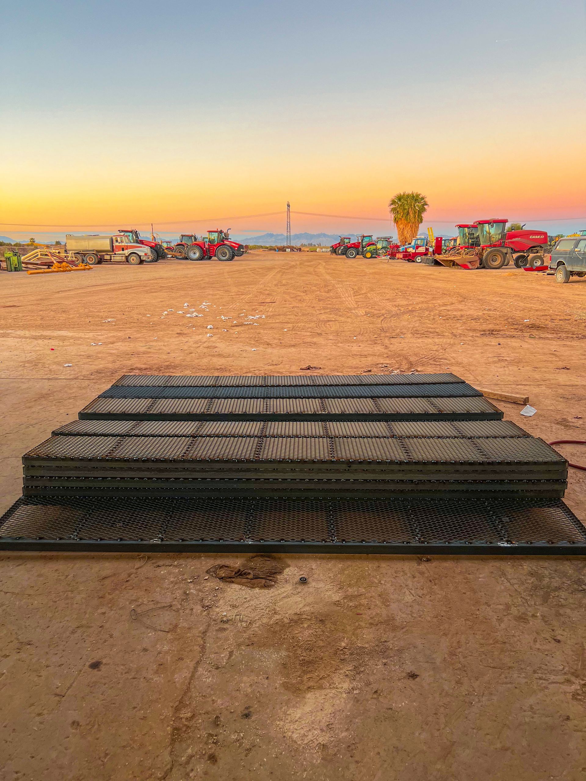 A stack of metal plates sitting on top of a dirt field.