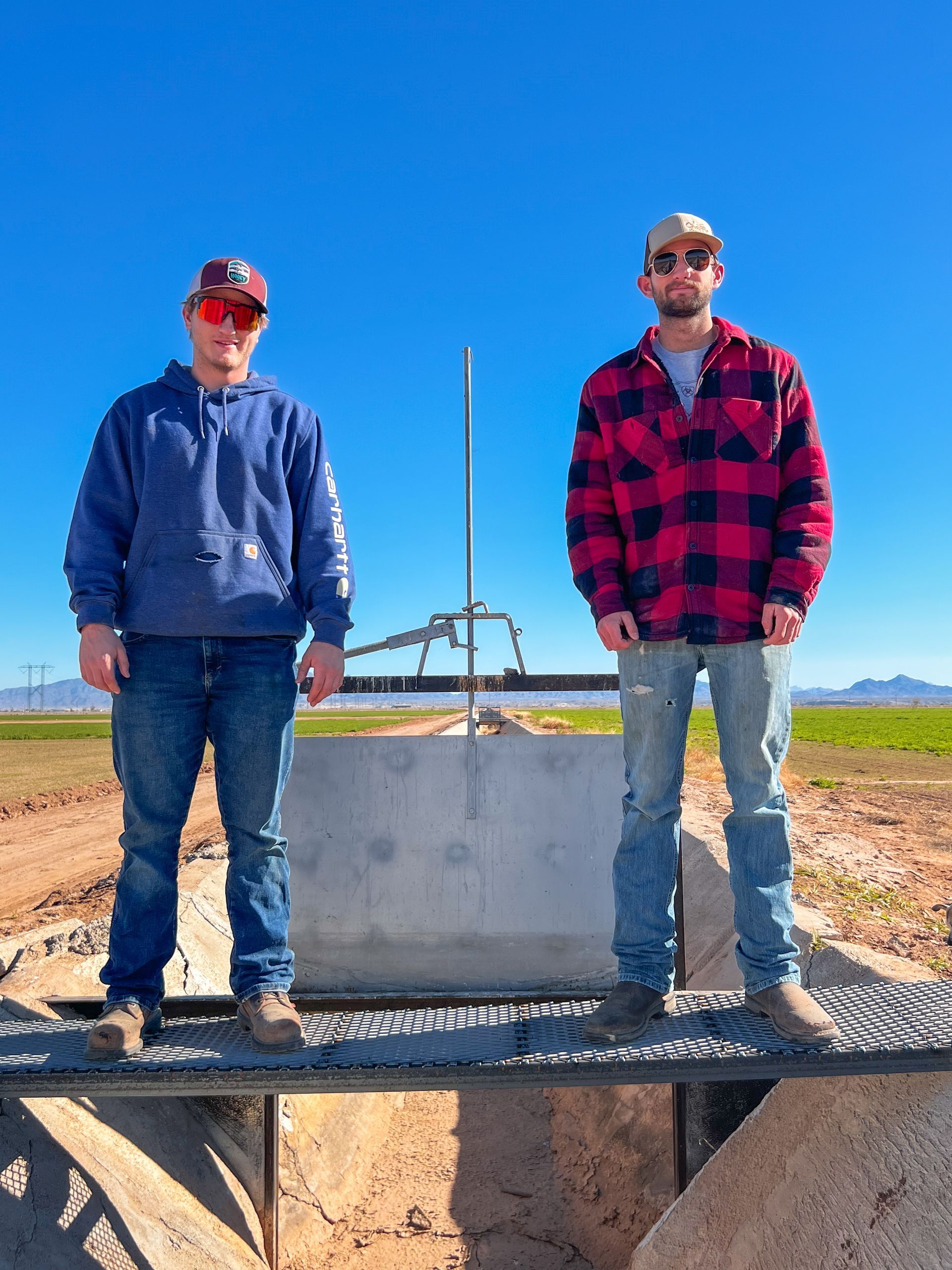 Two men standing next to each other in a field