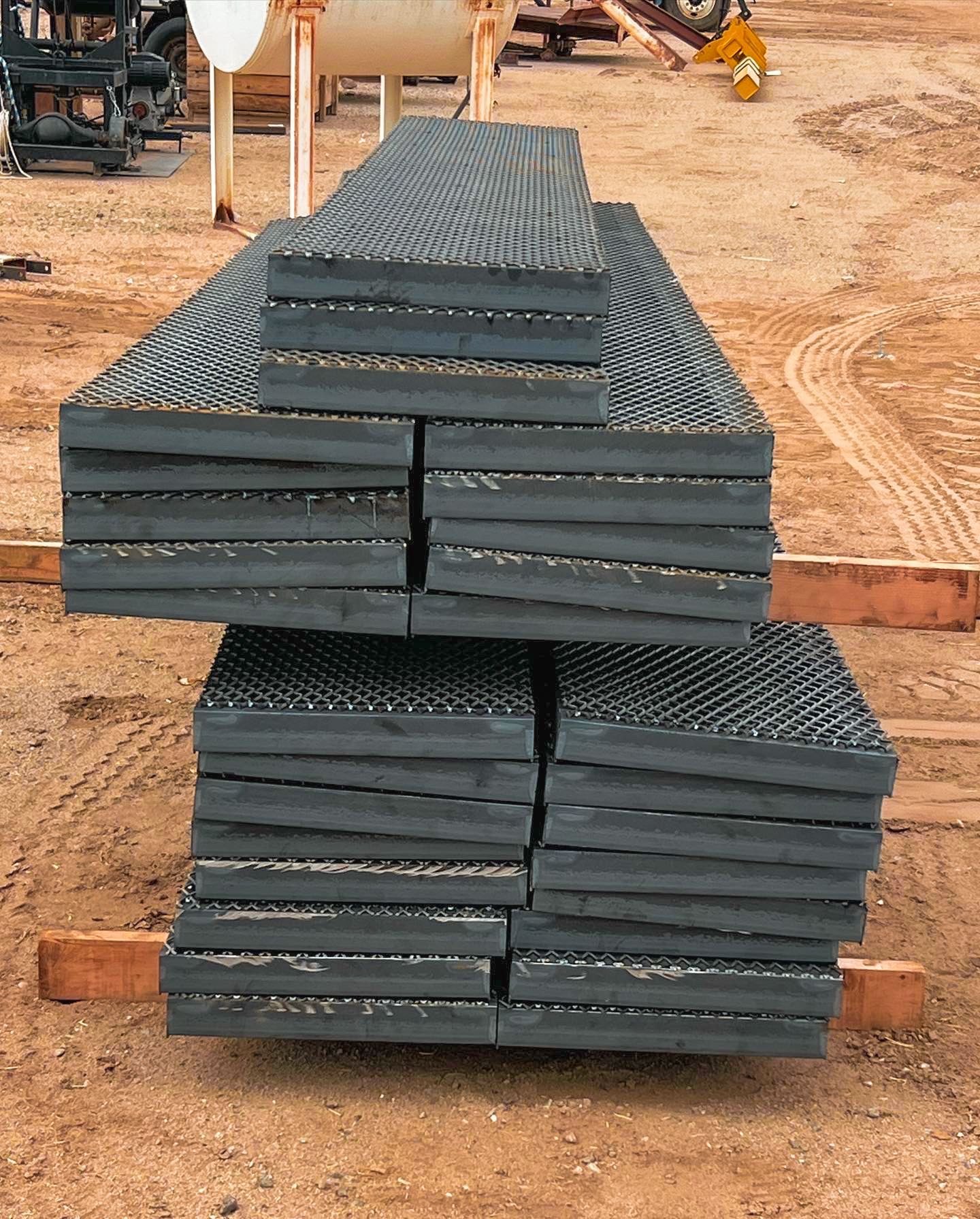 A stack of metal plates sitting on top of each other on a dirt ground.