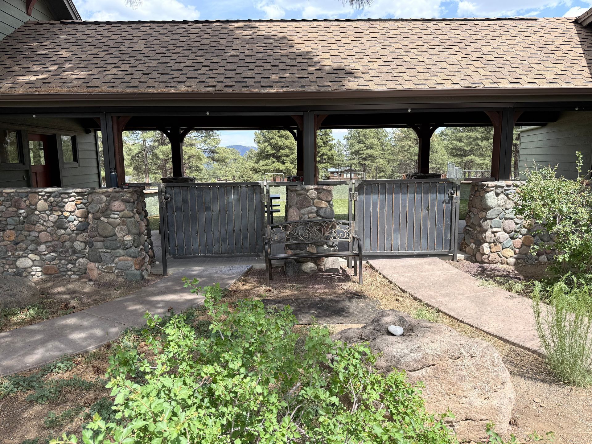 A man is welding a metal fence in a field.