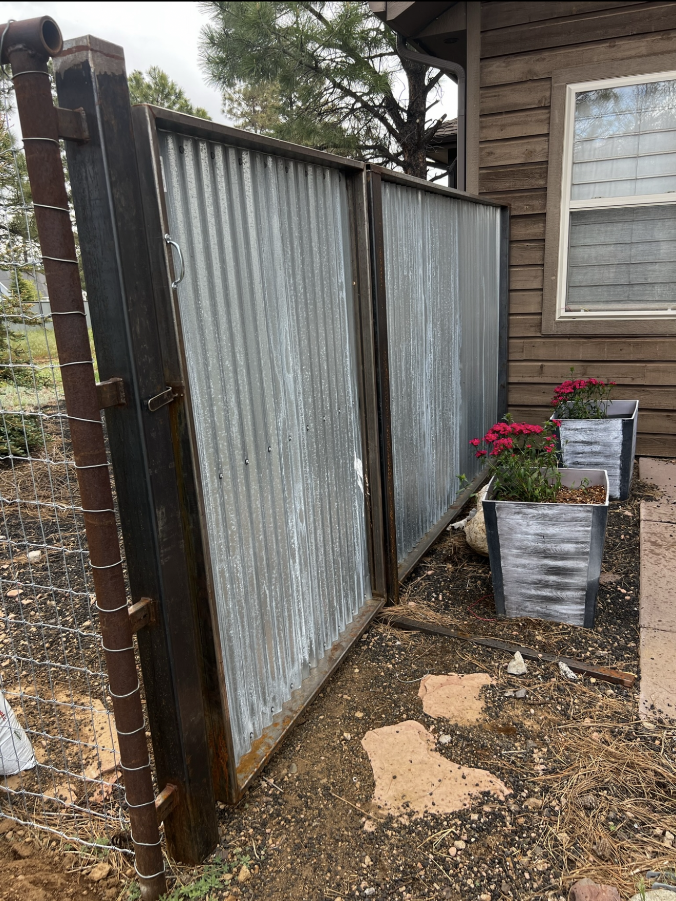 A man is standing next to a fence in a field.