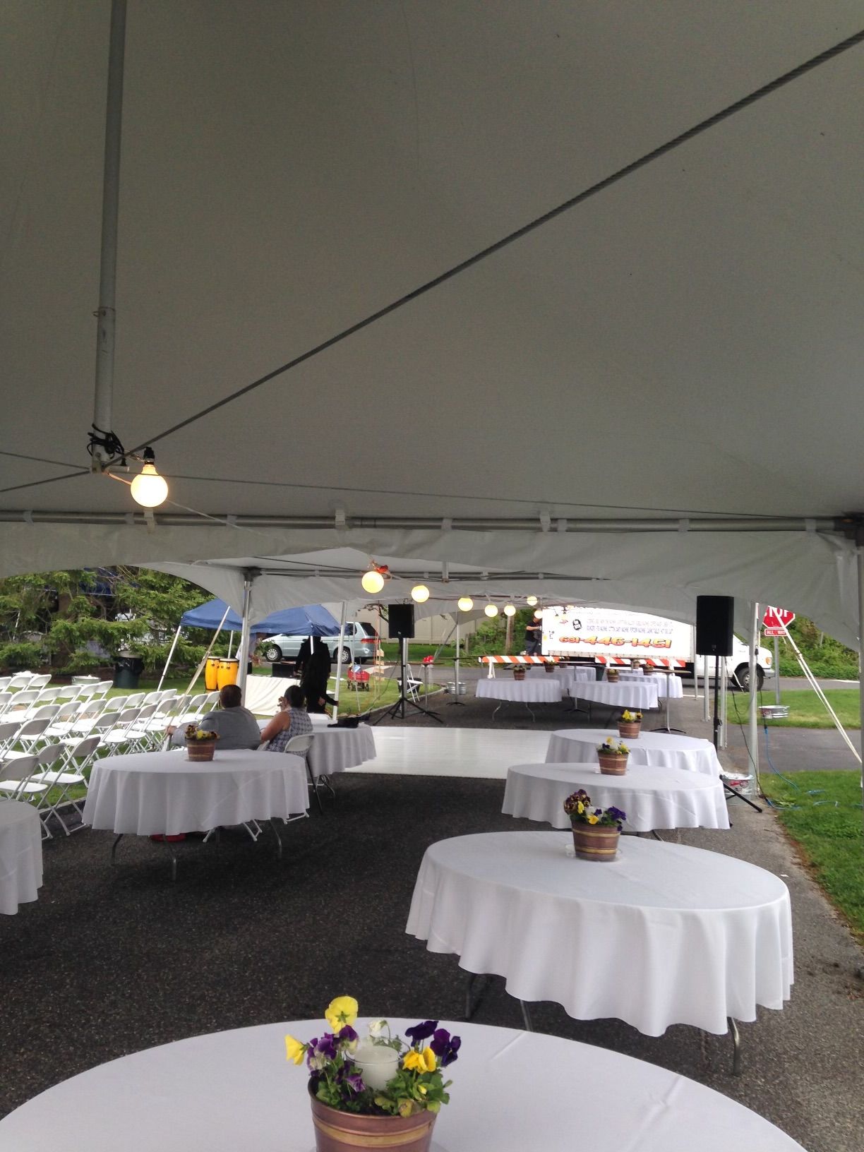 Tables under a tent with flowers on them