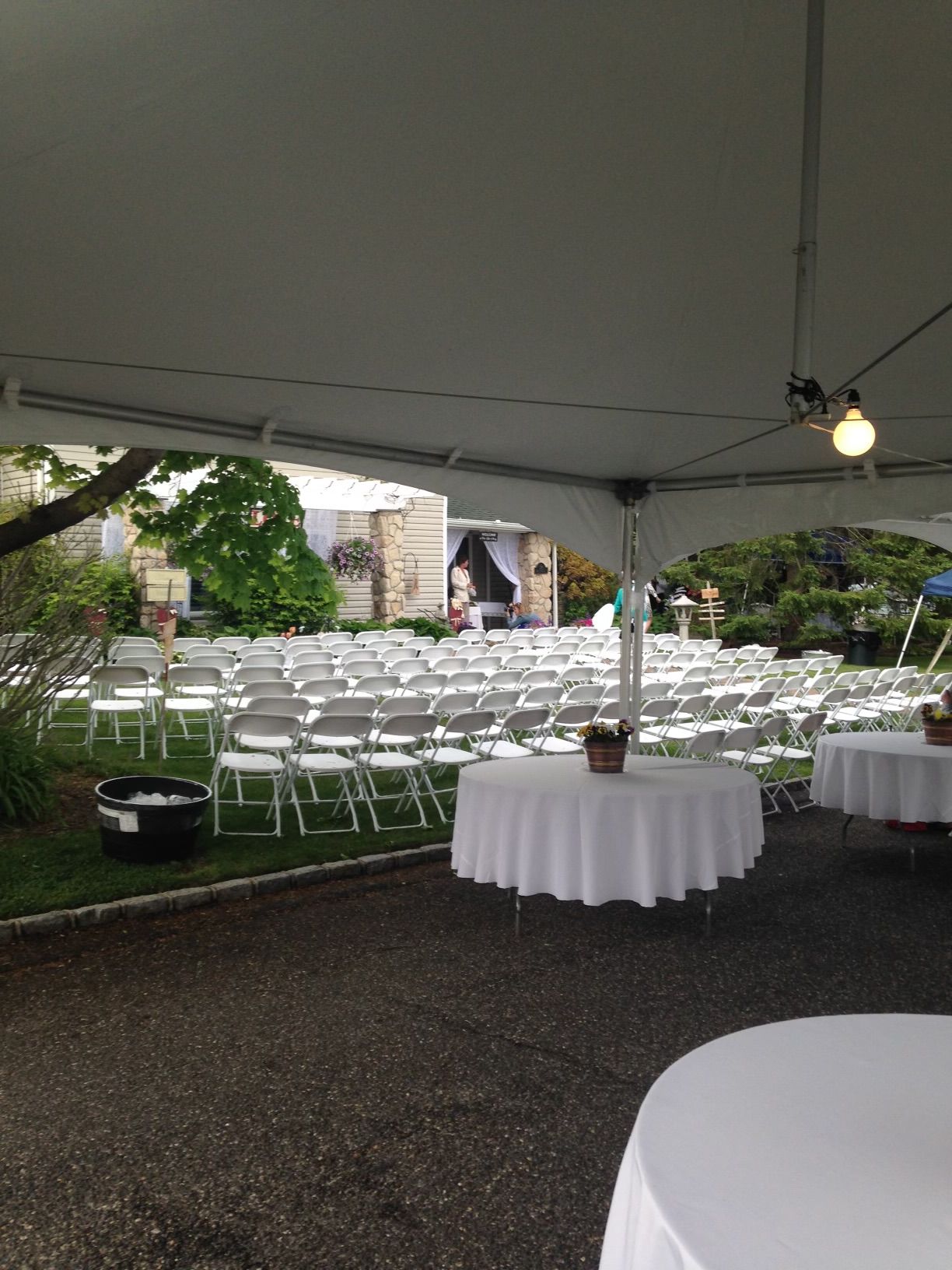 A white tent with tables and chairs underneath it