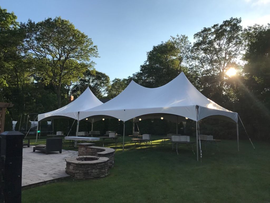 The sun is shining through the trees behind the tents