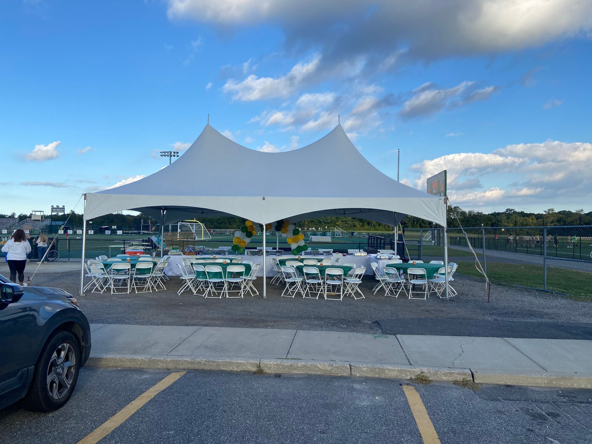Tables and chairs under a tent in a parking lot