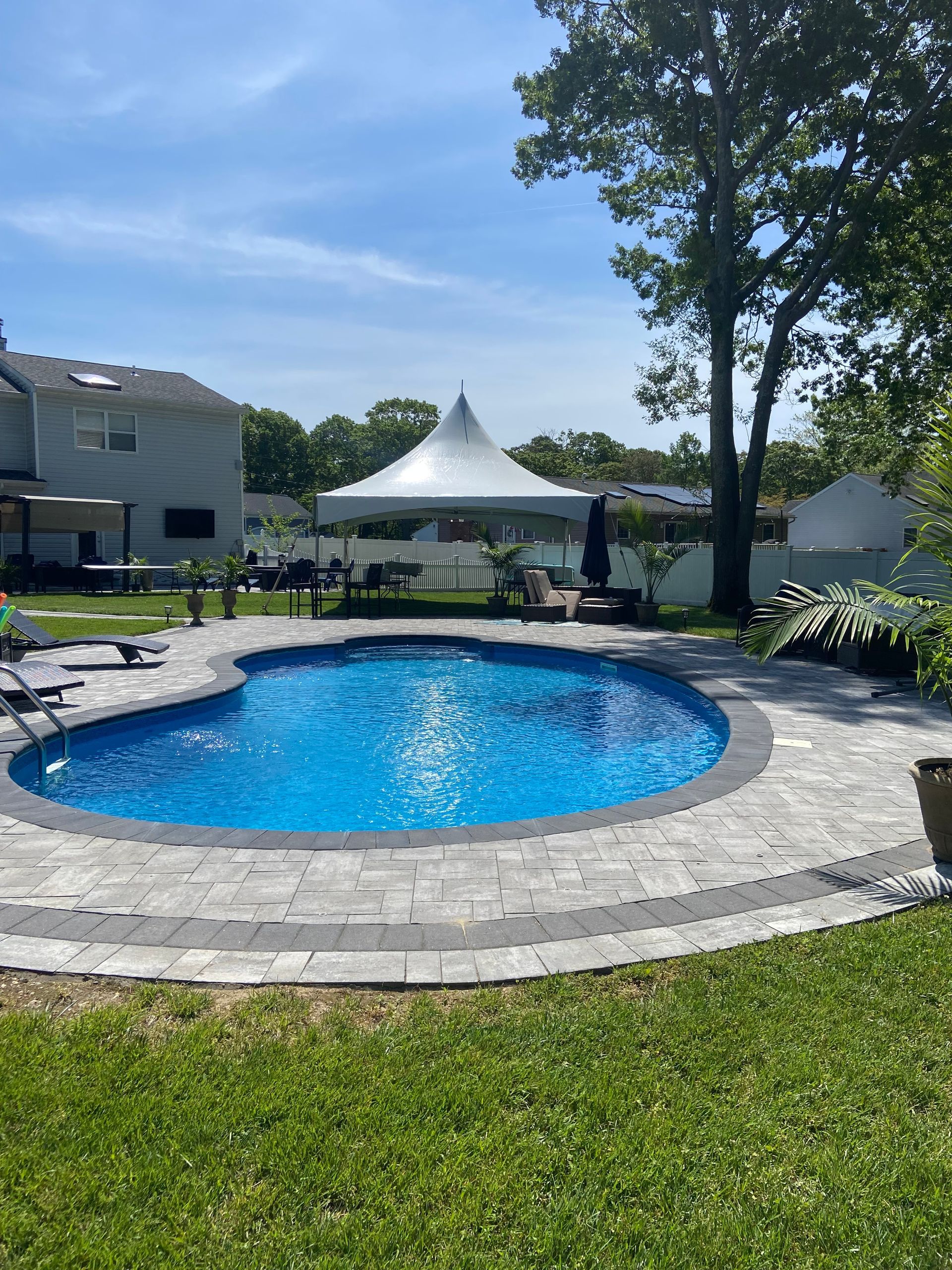 A large swimming pool with a white tent in the background