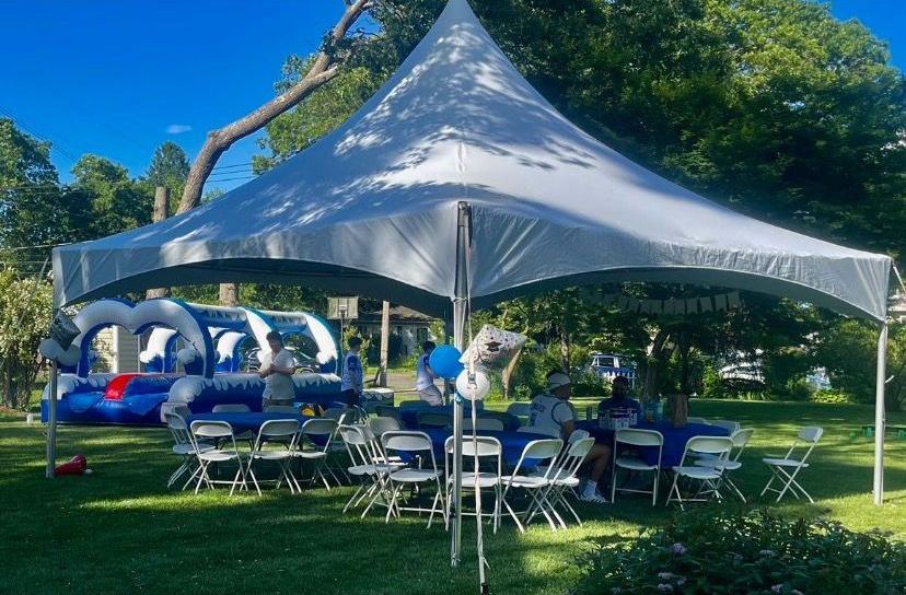 A white tent with tables and chairs underneath it